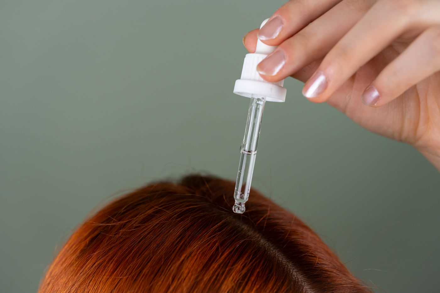Hair care formula being applied to the scalp at the roots